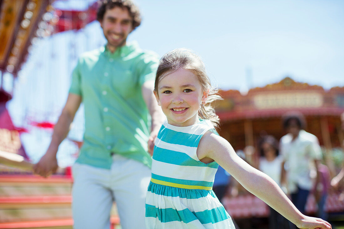 Girl pulling her father in amusement park