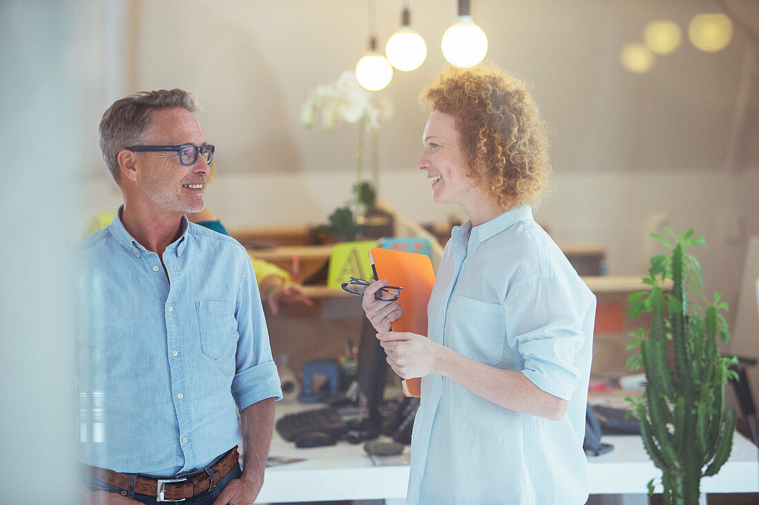 Three office workers talking at office