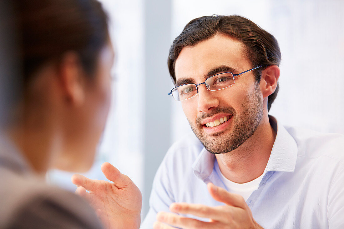 Smiling man in glasses with client