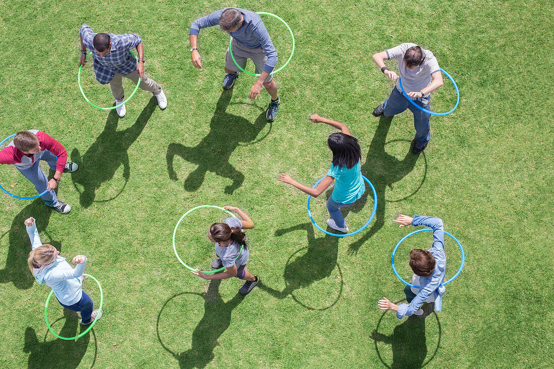 People spinning in plastic hoops
