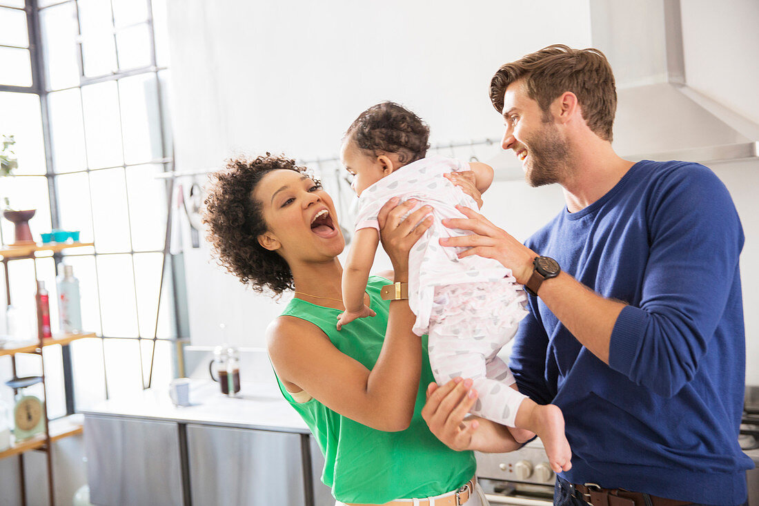 Happy parents holding their baby daughter