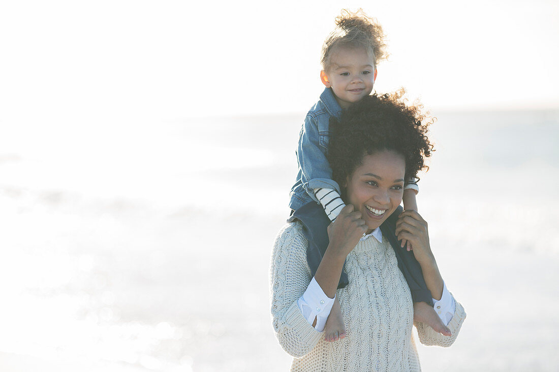 Mother carrying daughter on her shoulders