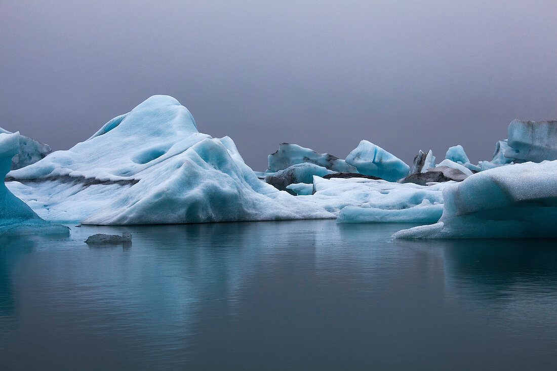 Blue icebergs in calm water