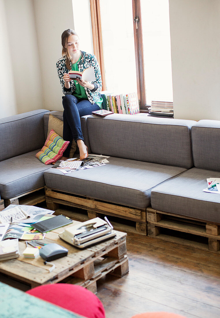 Businesswoman reading book at window