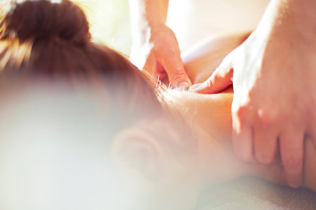 Close up masseuse massaging woman's neck