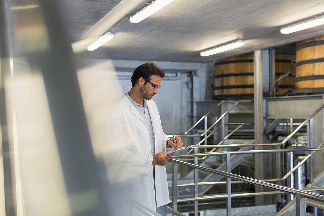 Vintner in lab coat in winery cellar