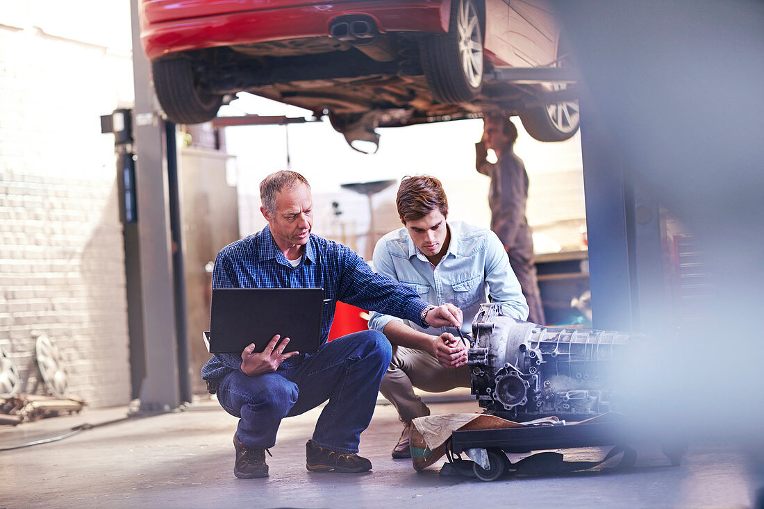 Mechanic and customer examining engine