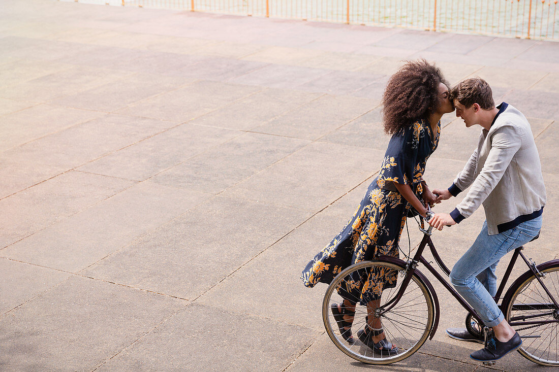 Affectionate woman kissing man on bicycle