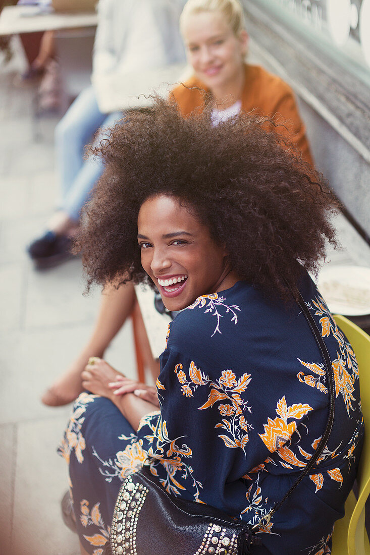 Portrait Woman with afro at sidewalk cafe