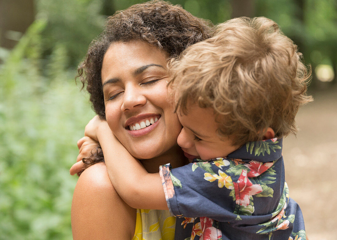 Mother and son hugging with eyes closed