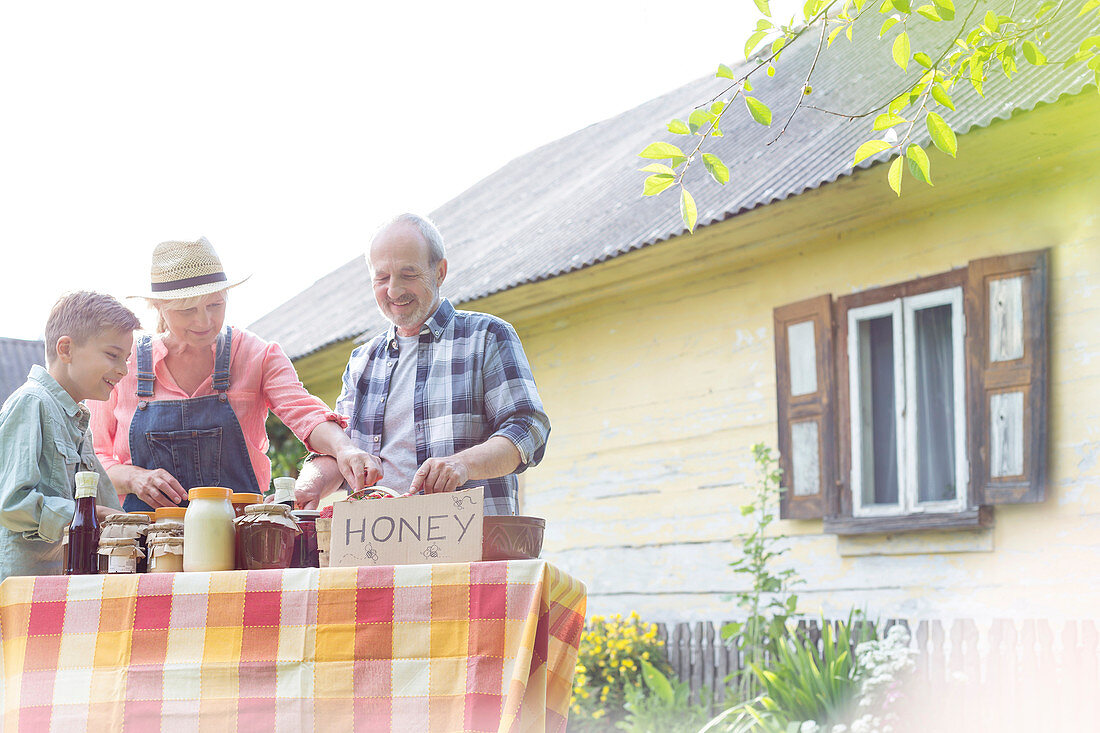Grandparents and grandson selling honey