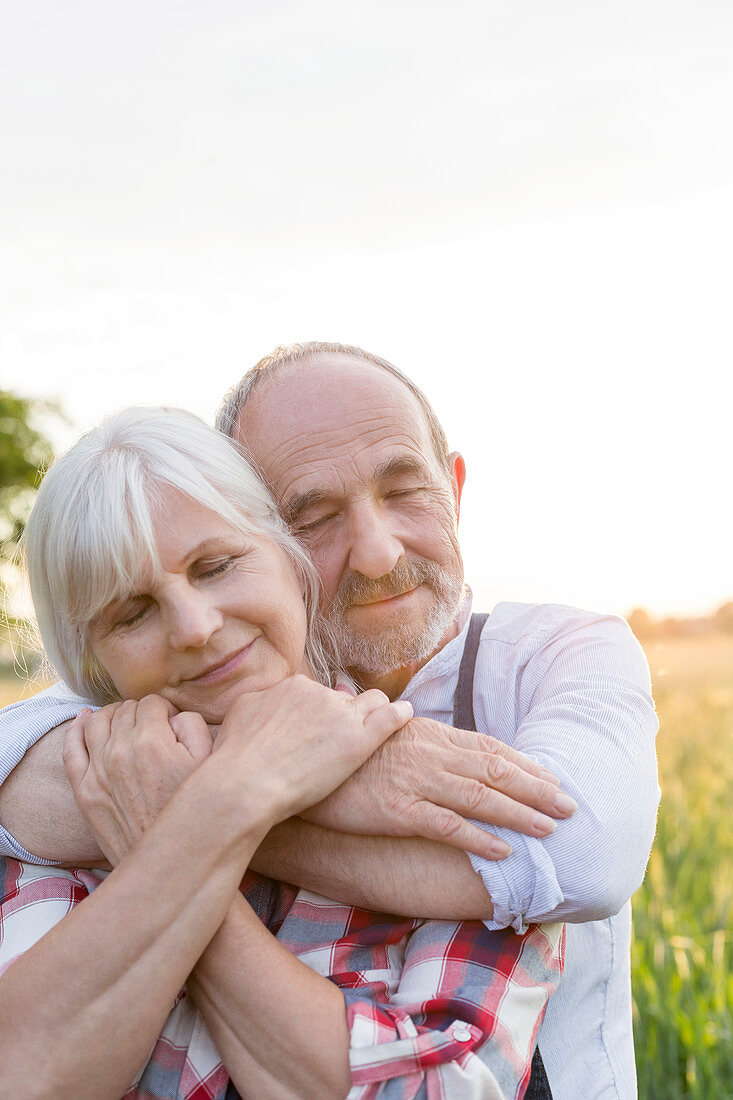 Senior couple hugging with eyes closed