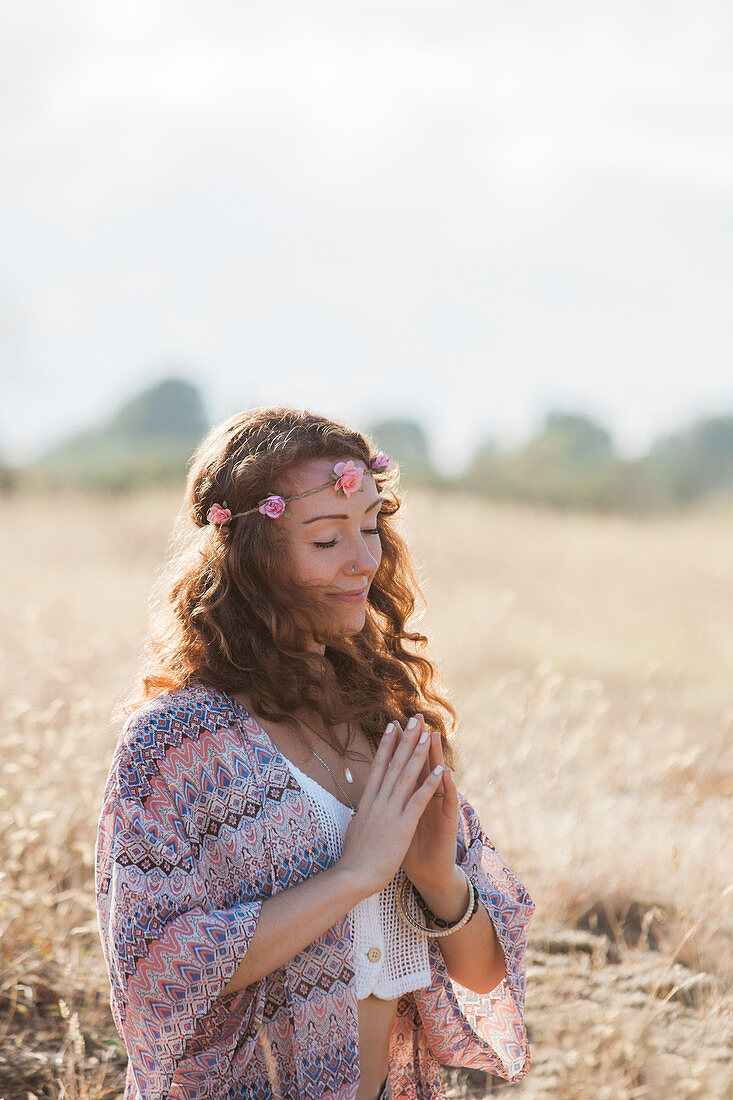 Serene boho woman meditating with hands