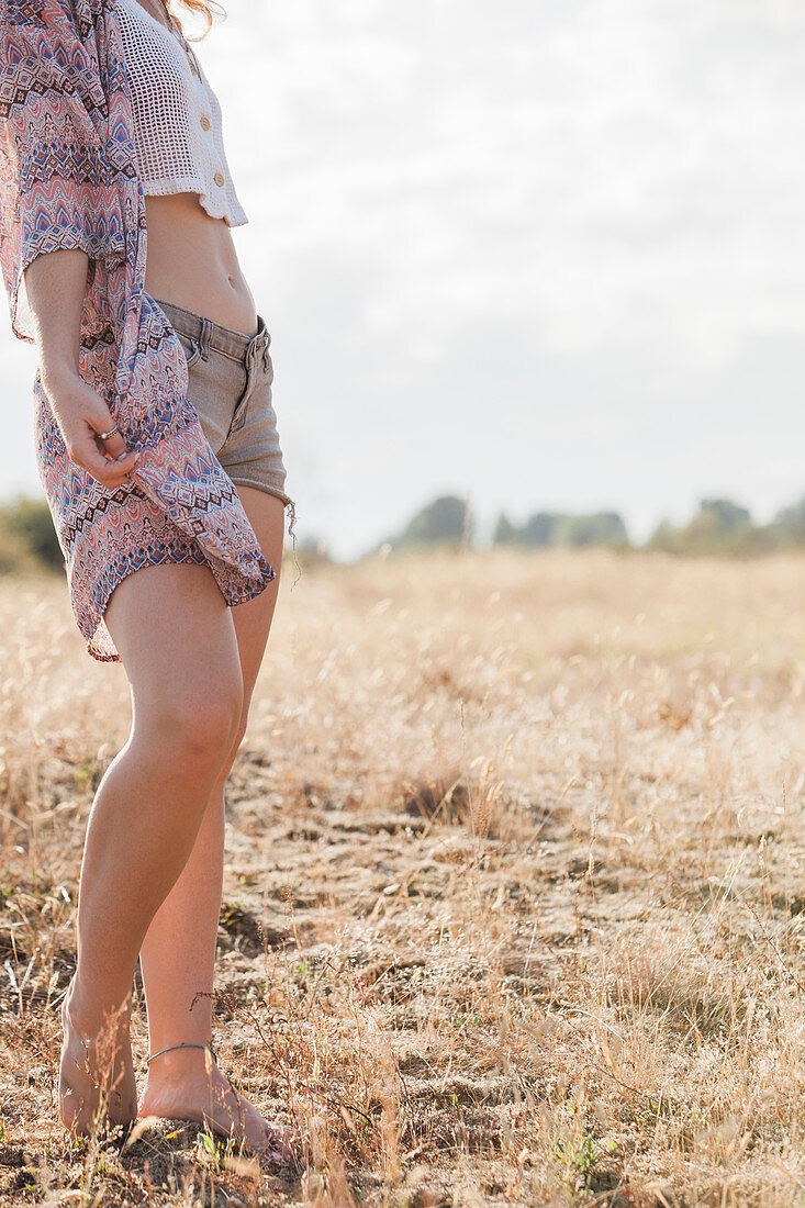 Boho woman standing in sunny rural field