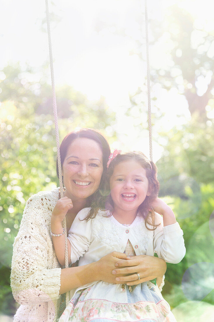 Portrait mother hugging daughter in park