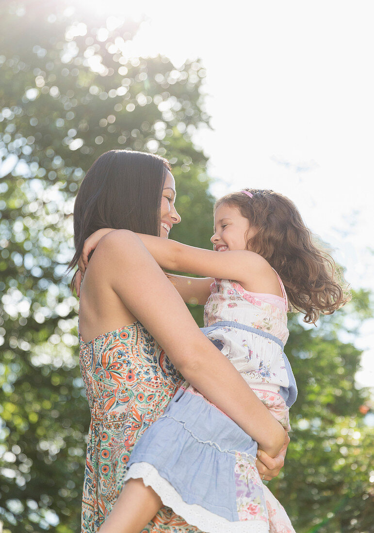 Mother holding and hugging daughter