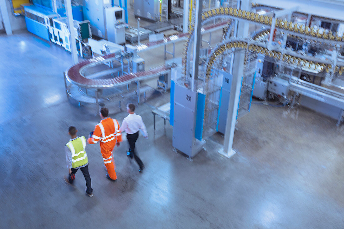 Workers and supervisor walking in factory