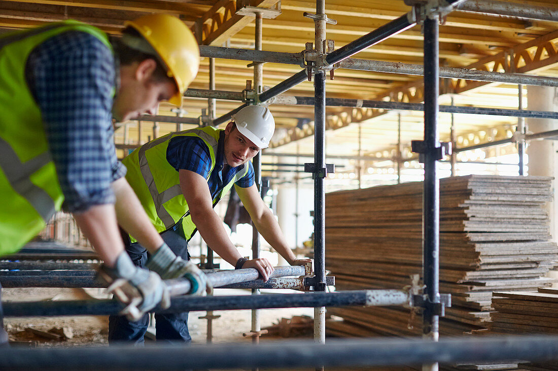 Construction workers adjusting metal bar