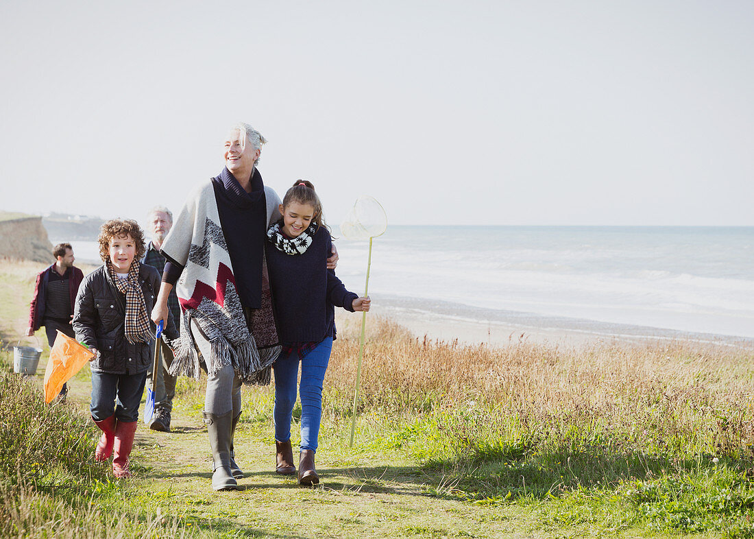 Family walking on grassy beach path