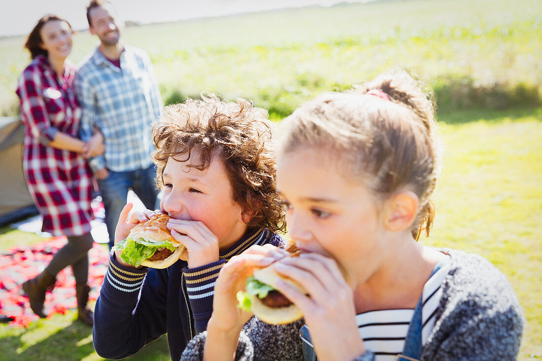 Brother and sister eating hamburgers