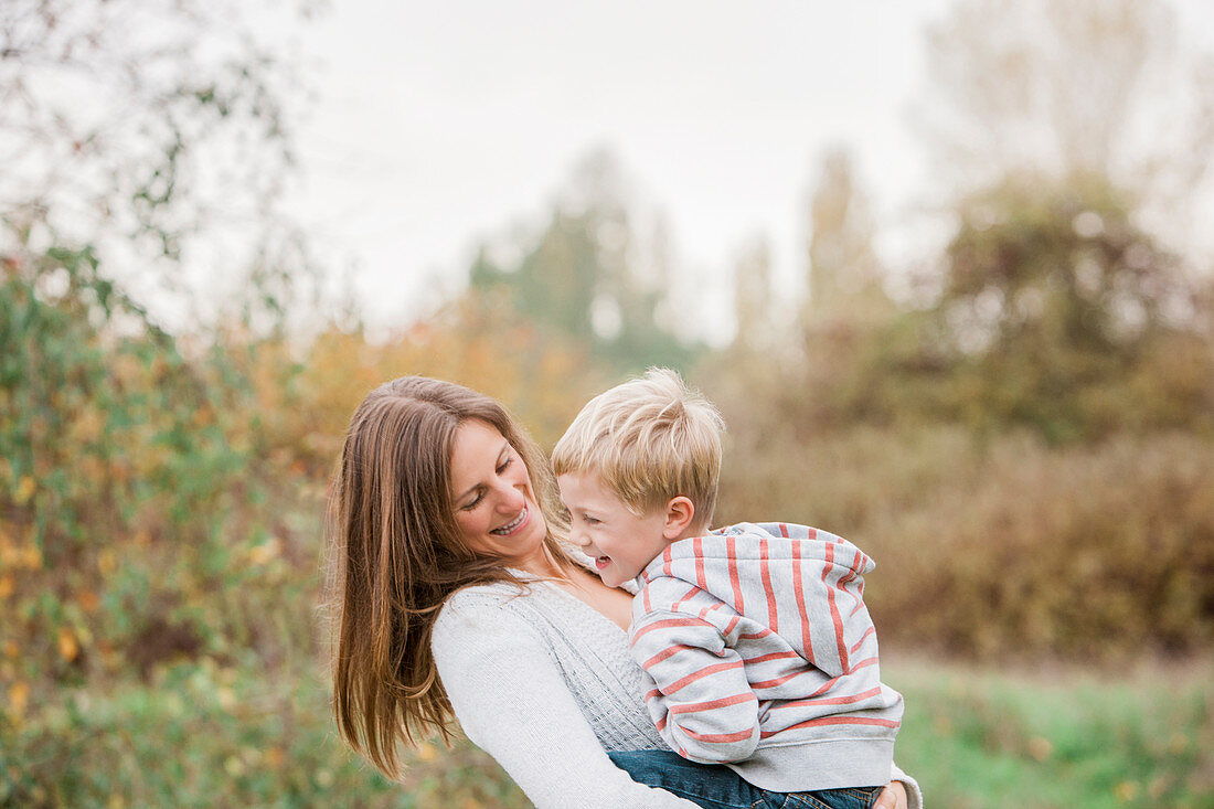 Mother and toddler son laughing in park