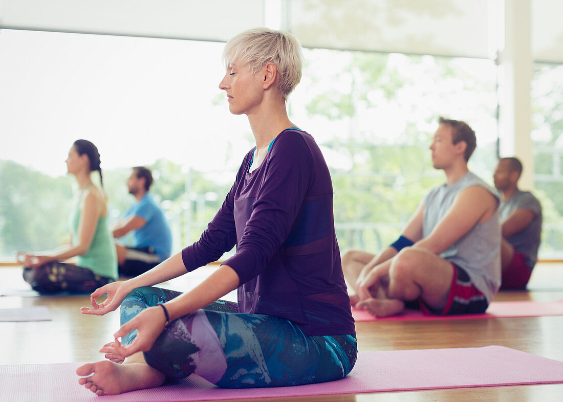 Woman in lotus position in yoga class
