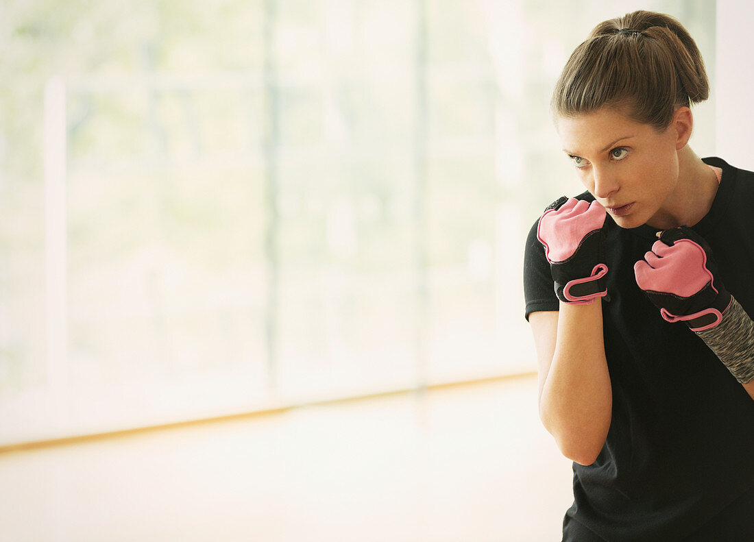 Focused woman shadow boxing in gym studio