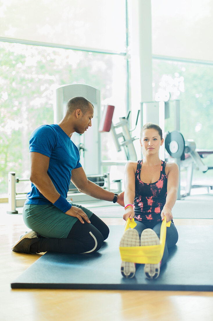 Personal trainer guiding woman
