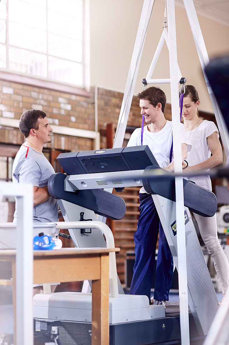 Physiotherapists helping man on treadmill