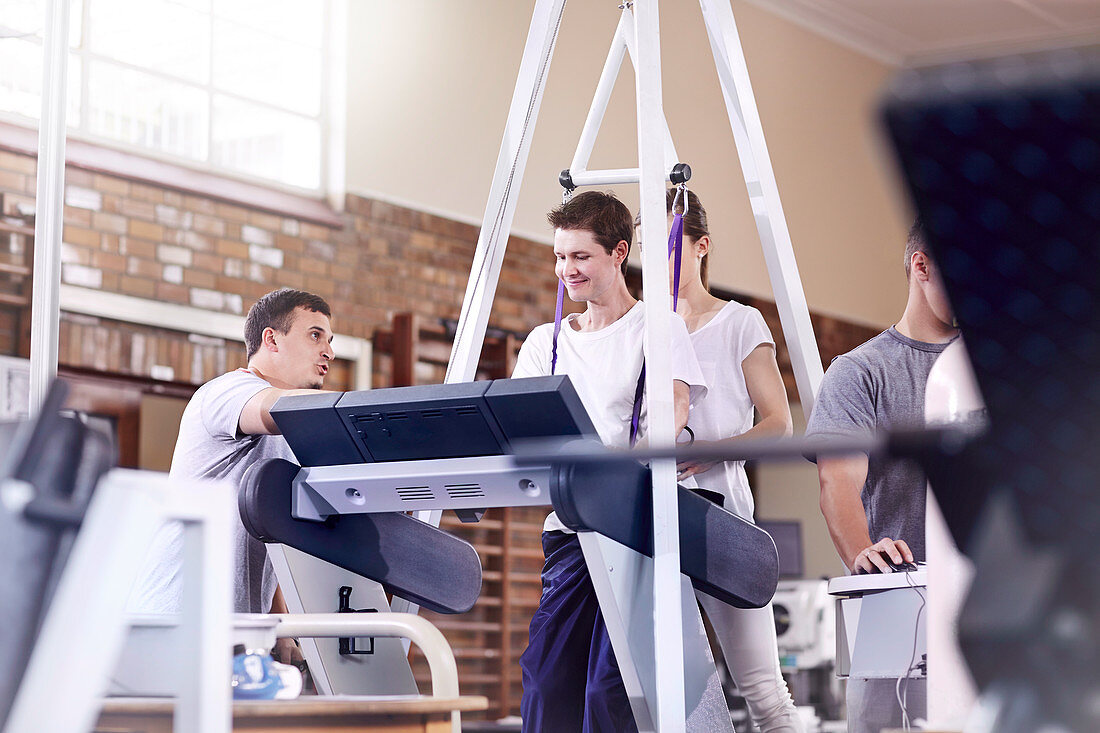 Physiotherapists guiding man on treadmill