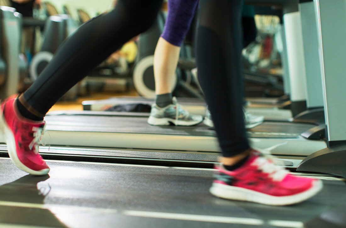 Woman's legs running on treadmill at gym