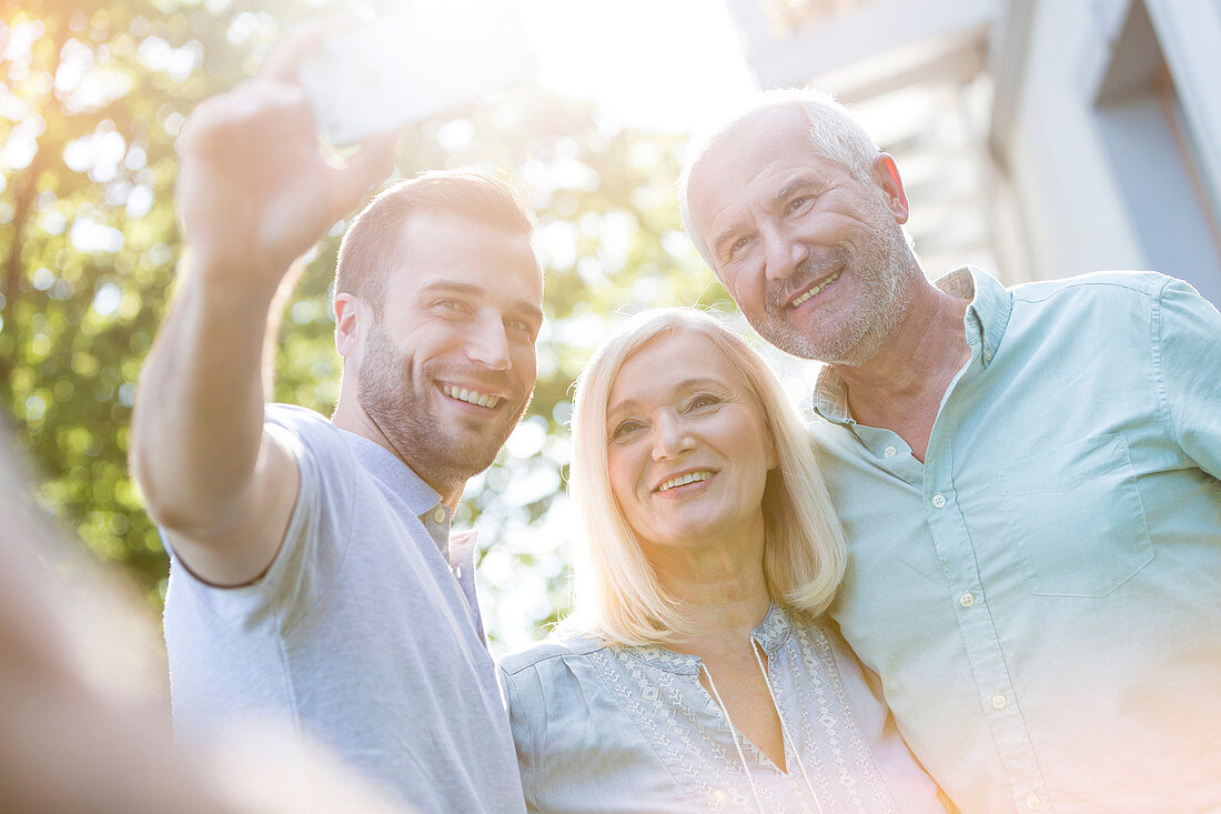 Senior couple and son taking selfie