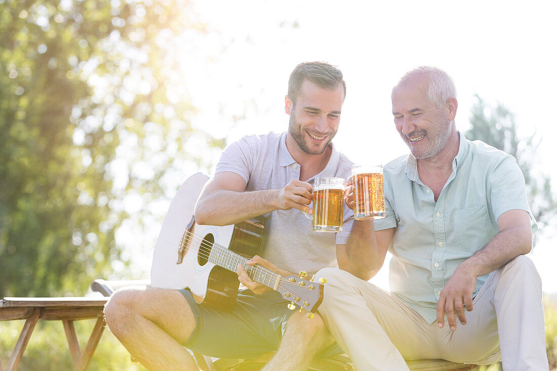 Father and adult son toasting beer