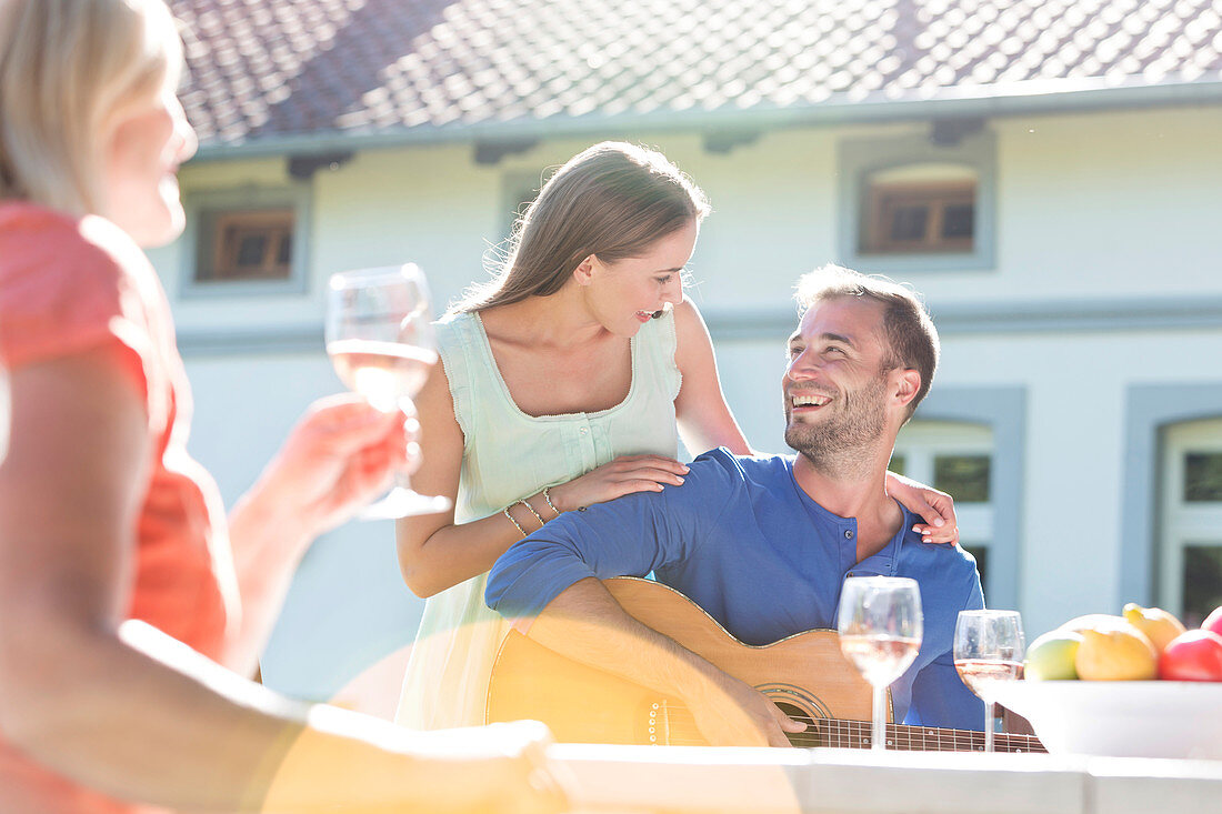 Couple playing guitar and drinking wine