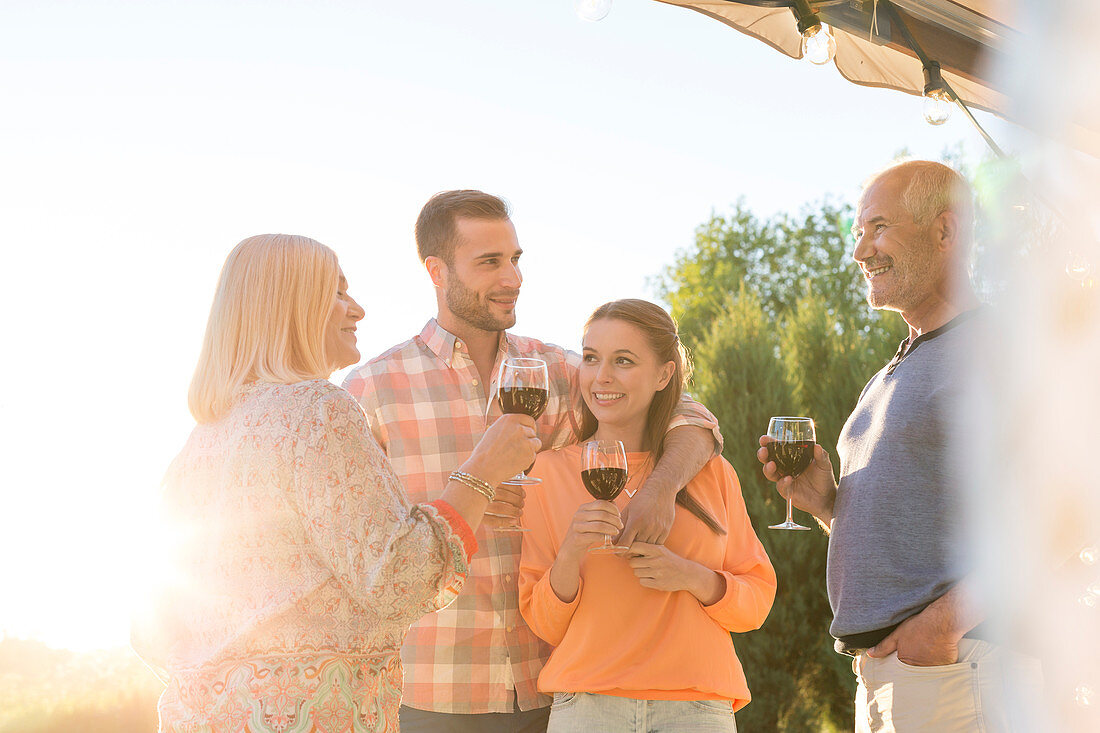 Family talking and drinking wine on patio