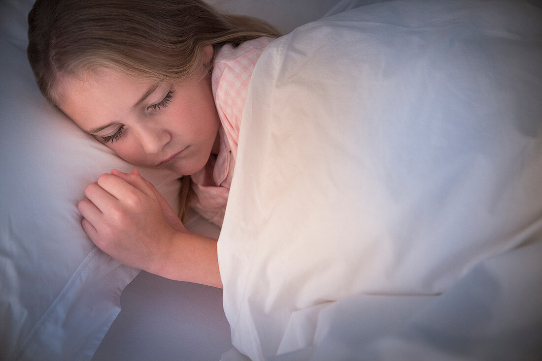 Serene girl sleeping in bed