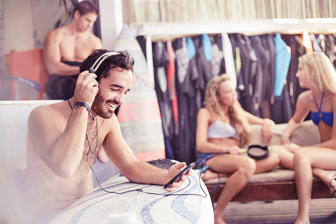 Smiling surfer listening to music