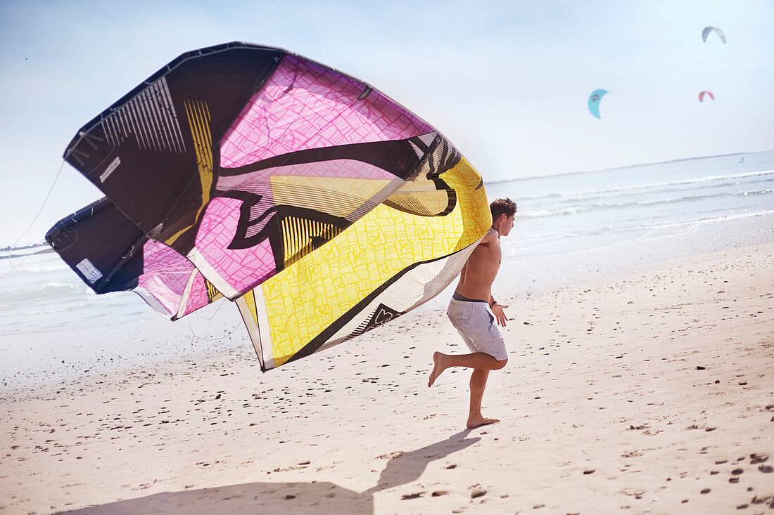 Man running with kiteboarding kite