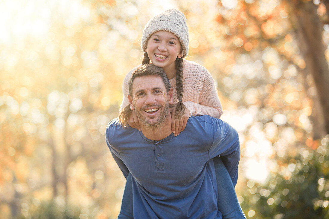 Father piggybacking daughter outdoors