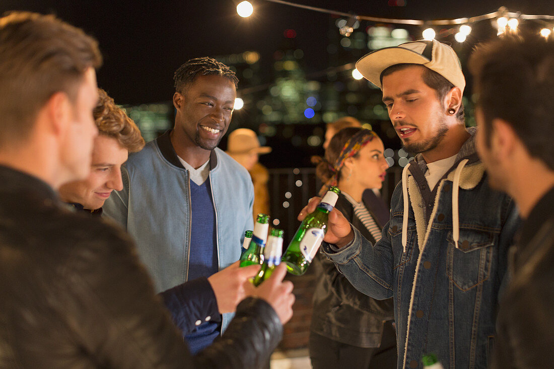 Young adult friends toasting beer bottles
