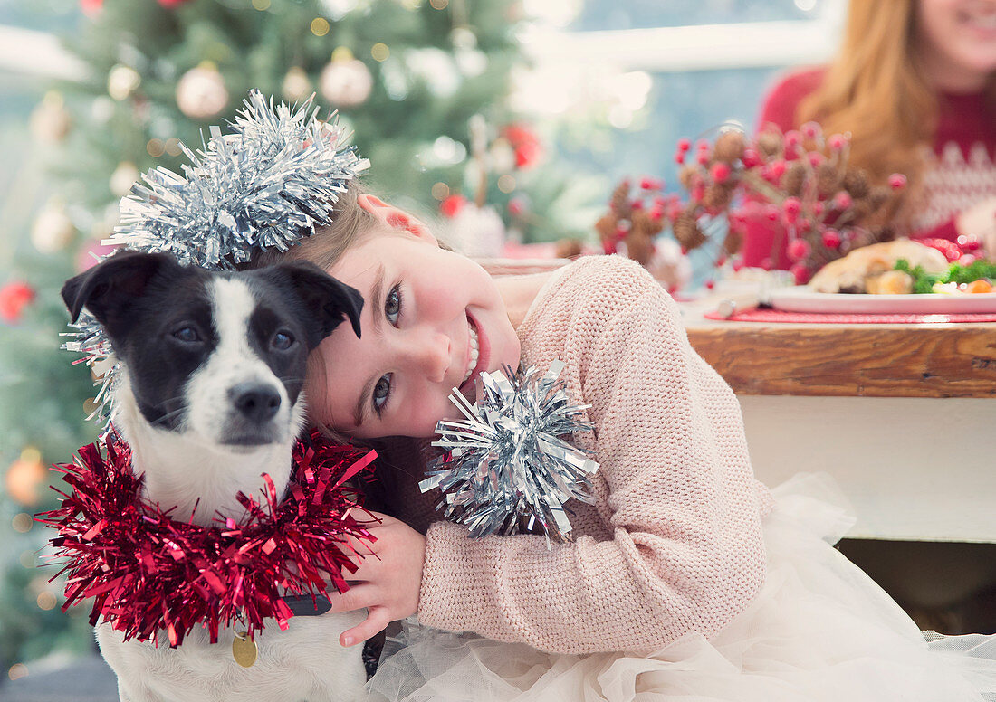 Girl hugging dog at Christmas