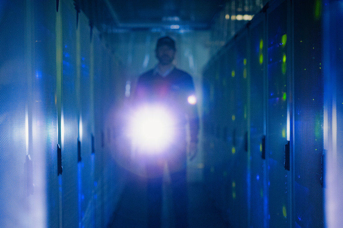 Server room technician with flashlight