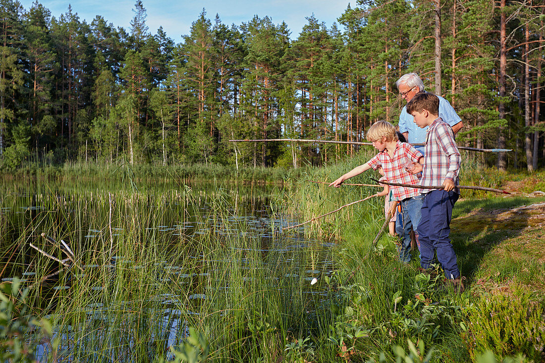 Grandfather teaching grandsons fishing