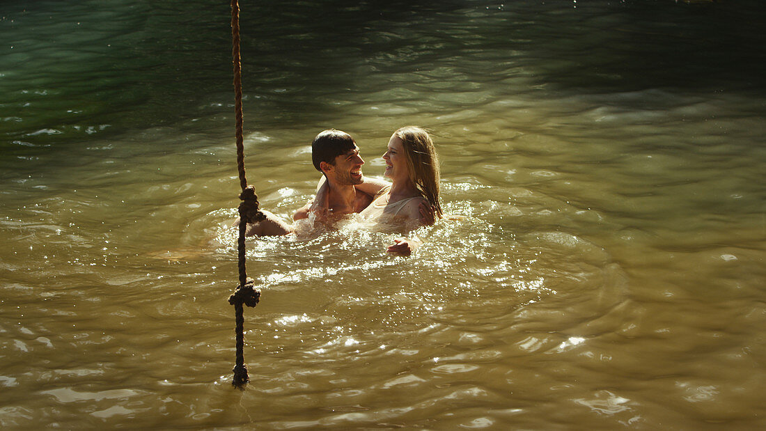 Young couple swimming in sunny lake