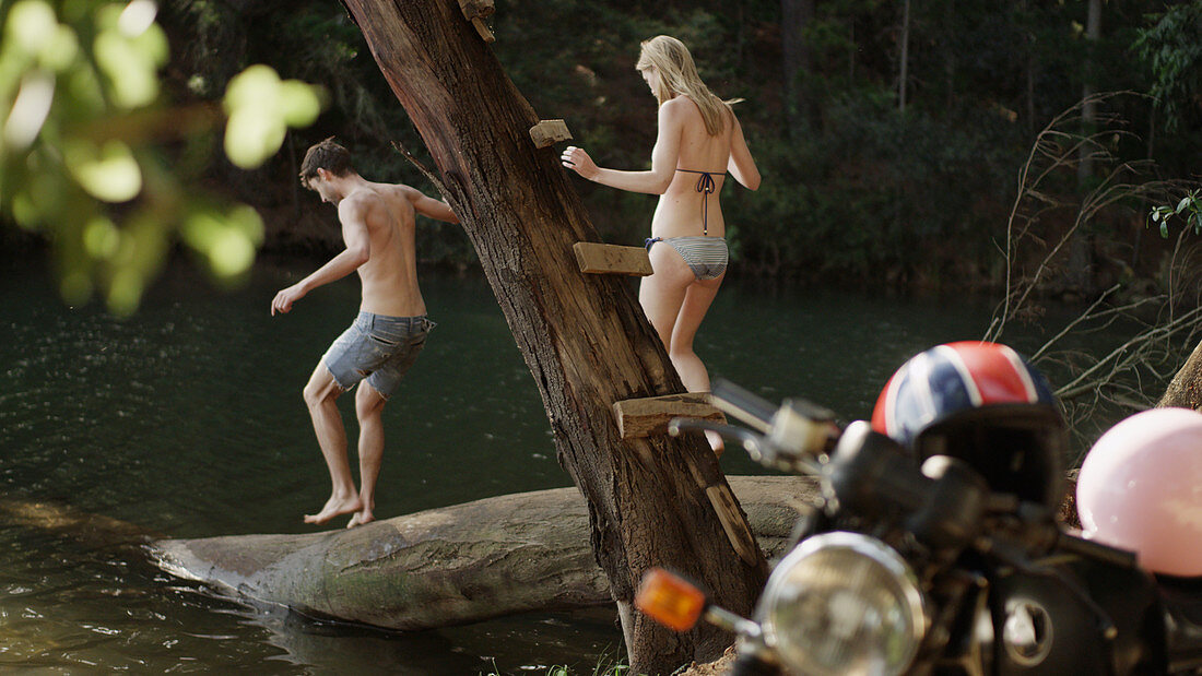 Young couple on log at lakeside