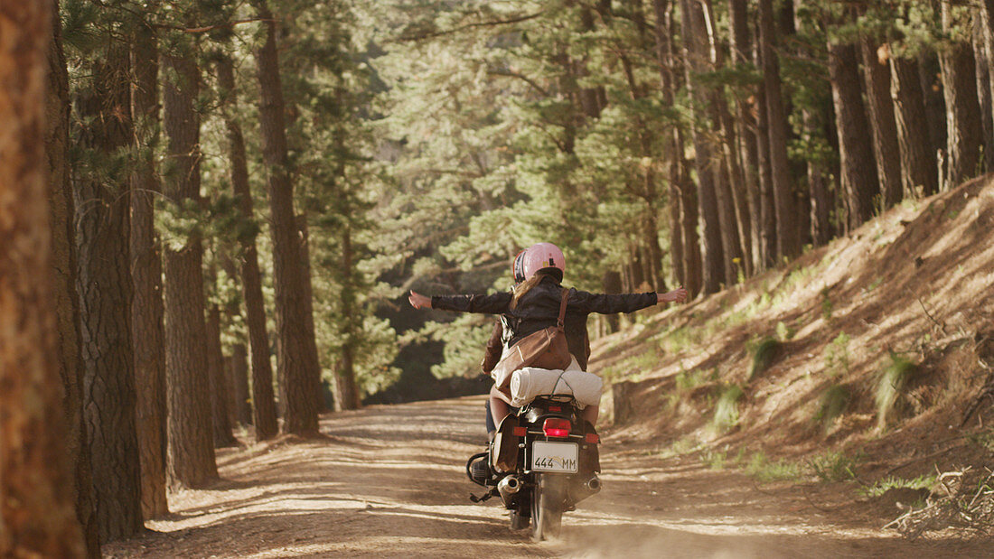 Exuberant young woman riding motorcycle