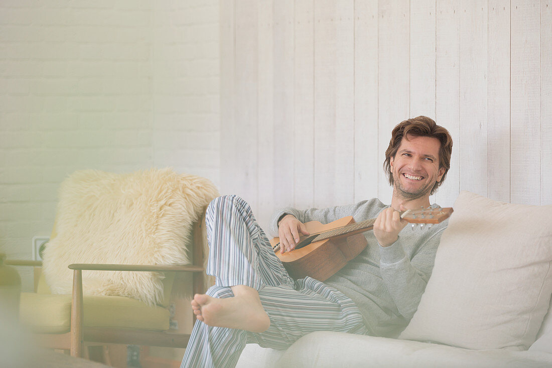 Man in pyjamas playing guitar