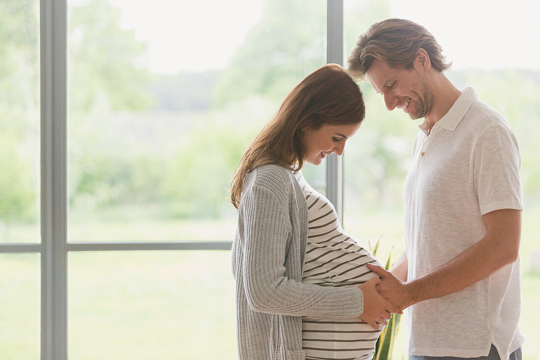 Pregnant couple touching stomach