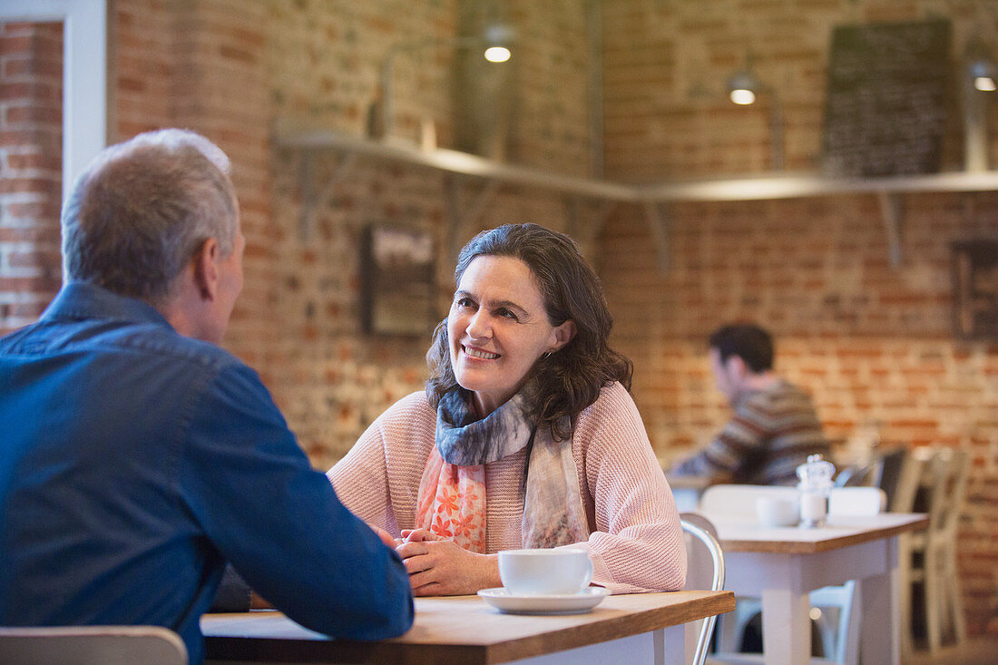 Smiling couple talking in cafe