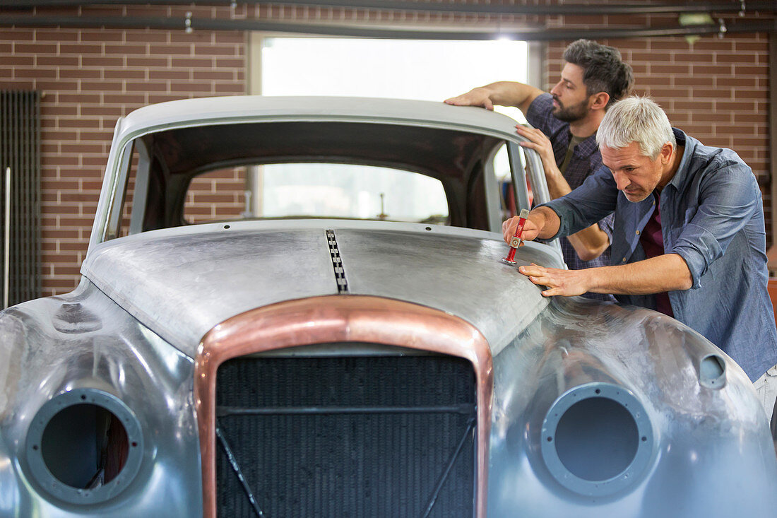 Mechanics rebuilding classic car